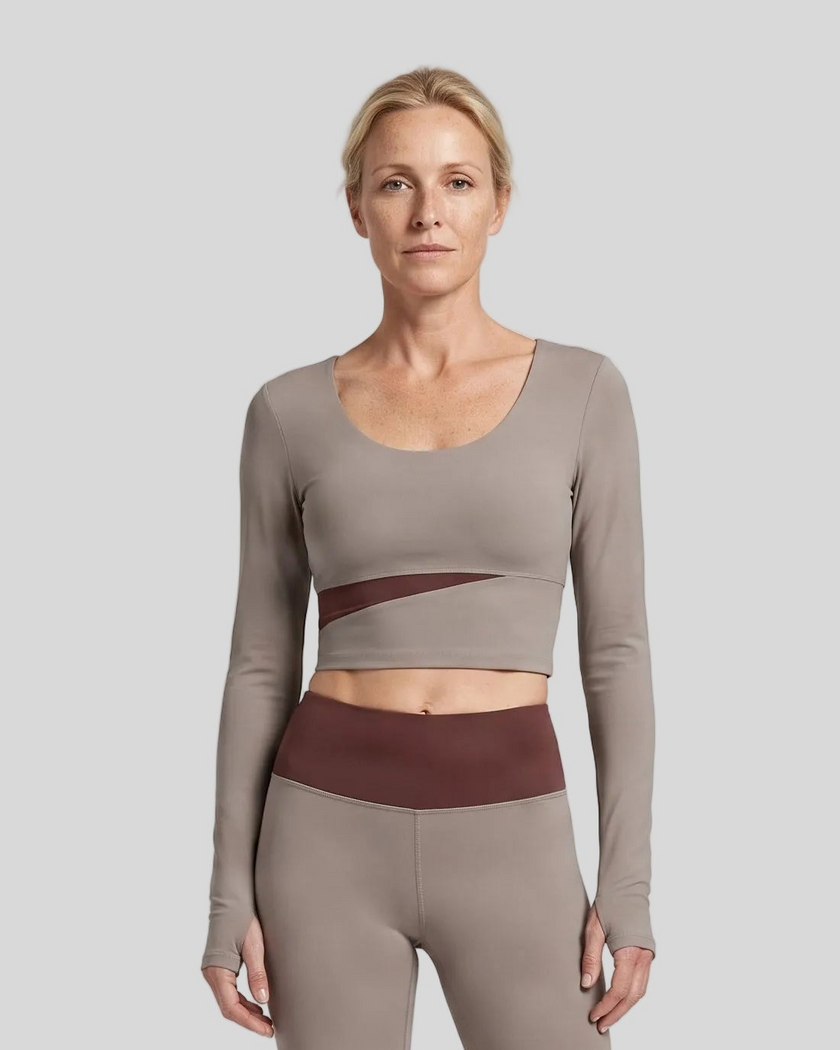 Woman wearing TrackLine Synergy Long Sleeve Top in gray purple with brick red asymmetric front detail