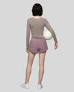 Full body back view of woman wearing TrackLine Synergy Long Sleeve Top in gray purple