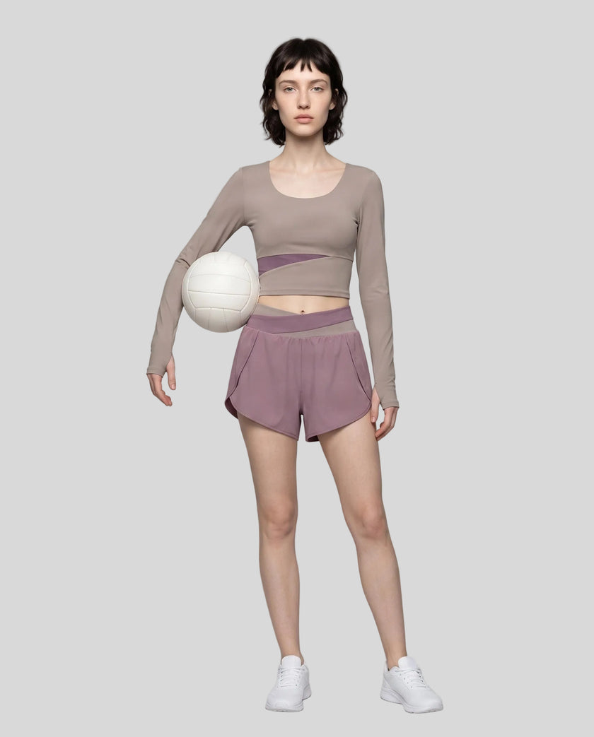 Full body view of woman wearing TrackLine Synergy Long Sleeve Top in gray purple with misty purple color-block detail