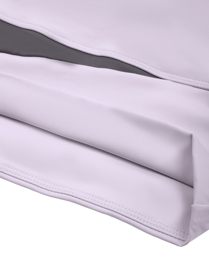 Closeup of asymmetric light purple and deep purple hem detail on TrackLine Synergy Long Sleeve Top