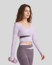 Woman wearing TrackLine Synergy Long Sleeve Top in light purple with deep purple asymmetric front detail