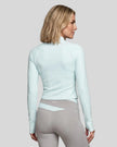 Woman wearing TrackLine Synergy Performance Jacket in Light Blue, back view