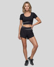 Woman wearing TrackLine Synergy Performance Shorts in Black with Dark Gray waistband, front view