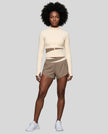 Woman wearing TrackLine Synergy Performance Shorts in Light Coffee with Apricot waistband, front view