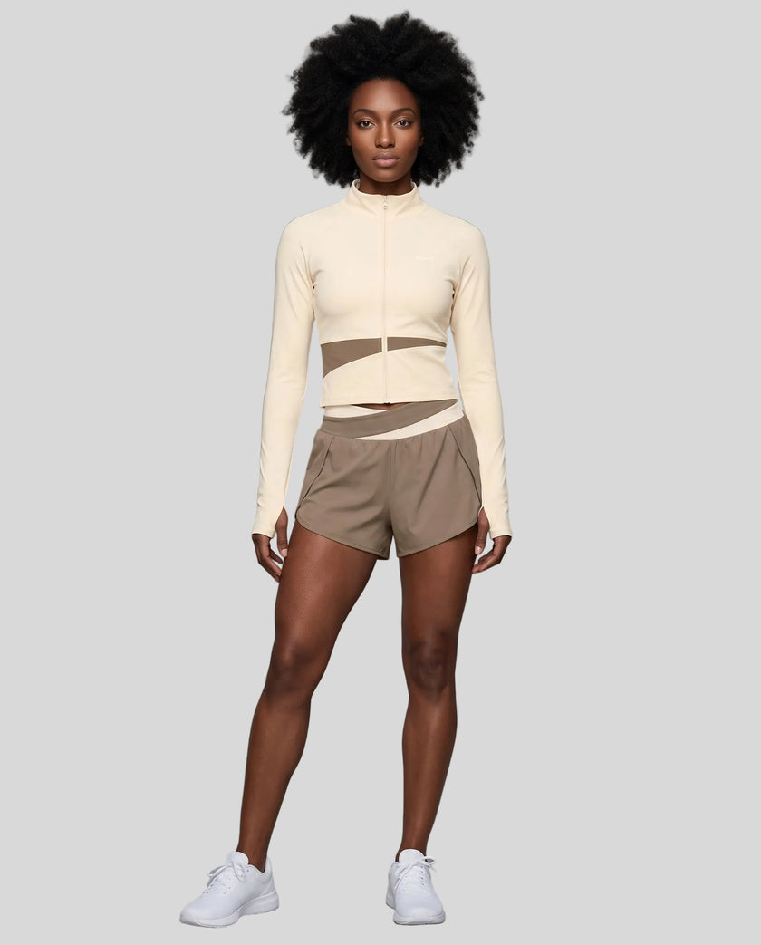 Woman wearing TrackLine Synergy Performance Shorts in Light Coffee with Apricot waistband, front view