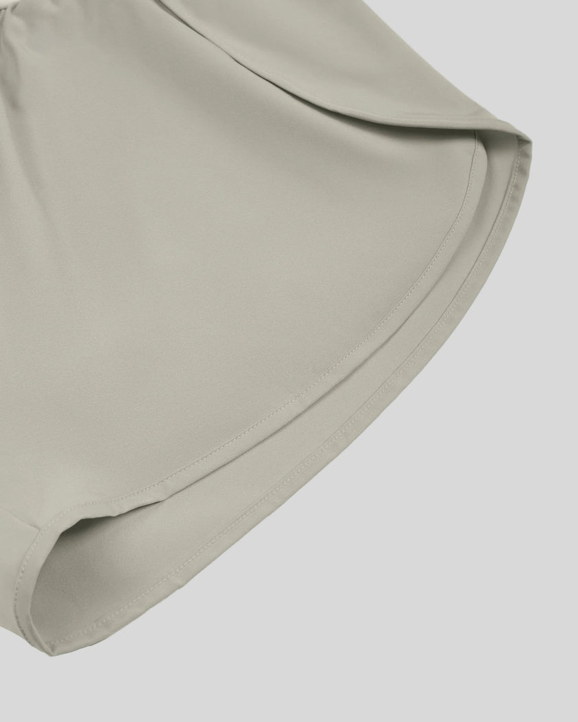Close-up of curved outer hem on TrackLine Synergy Performance Shorts in Light Gray