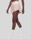 TrackLine Synergy Performance Shorts in Light Pink with Apricot color-block waistband, mid body side angle view