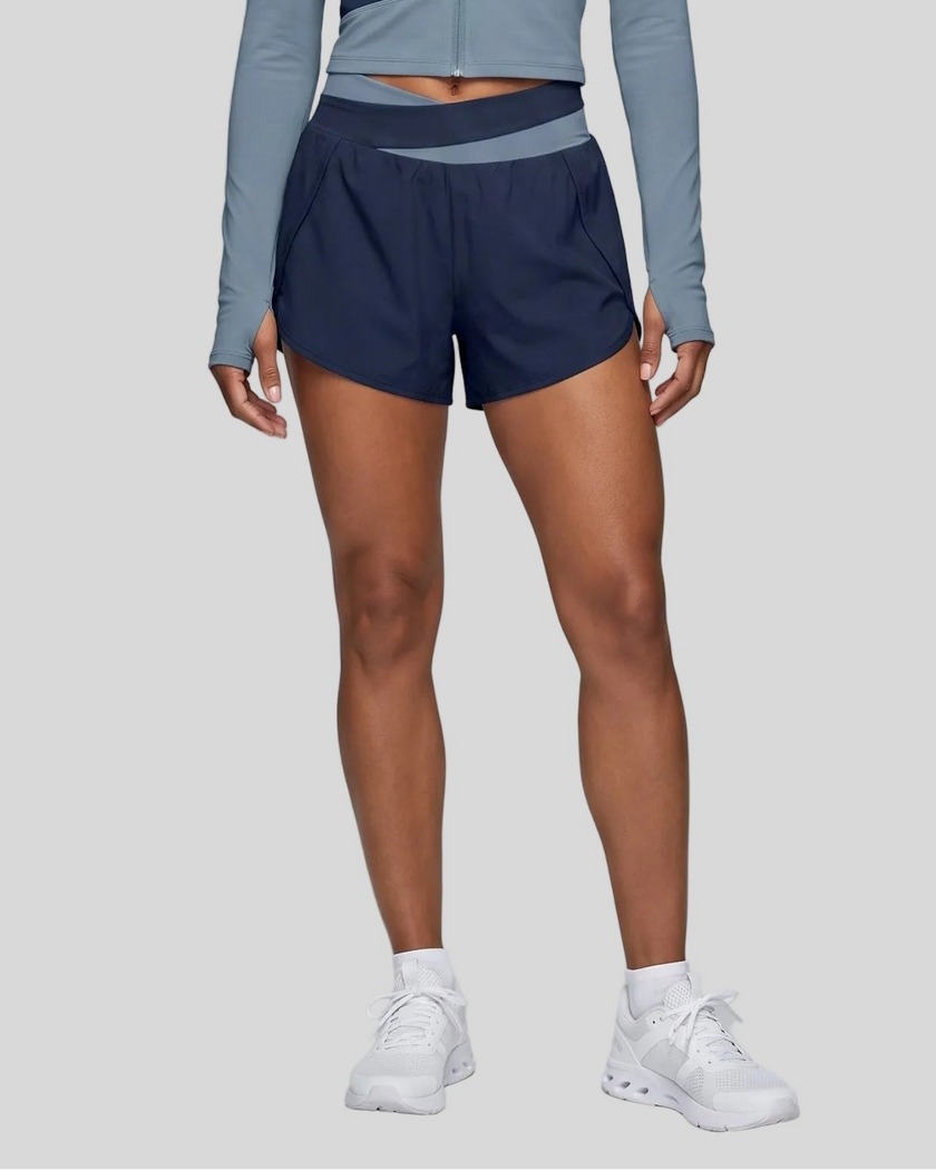 Woman wearing TrackLine Synergy Performance Shorts in Navy Blue with Gray Blue waistband, lower body front view