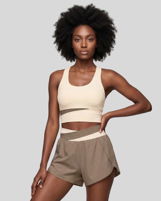Woman wearing TrackLine Synergy Racerback Sports Bra in Apricot with Khaki detail, front view