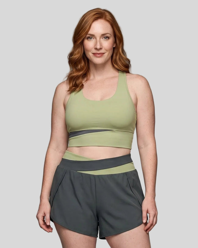 Woman wearing TrackLine Synergy Racerback Sports Bra in Bean Green with Dark Gray detail, front view