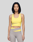 Woman wearing TrackLine Synergy Racerback Sports Bra in Lemon Yellow with Light Gray detail, front view