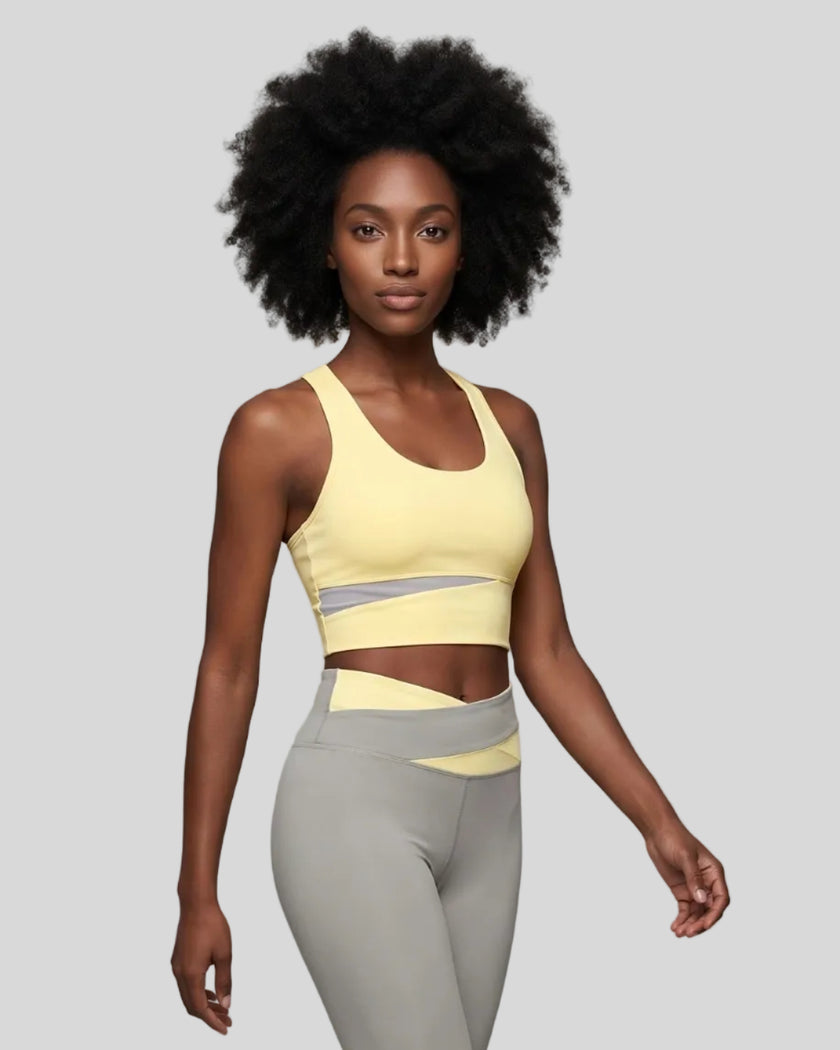 Woman wearing TrackLine Synergy Racerback Sports Bra in Light Yellow with Light Gray detail, front view