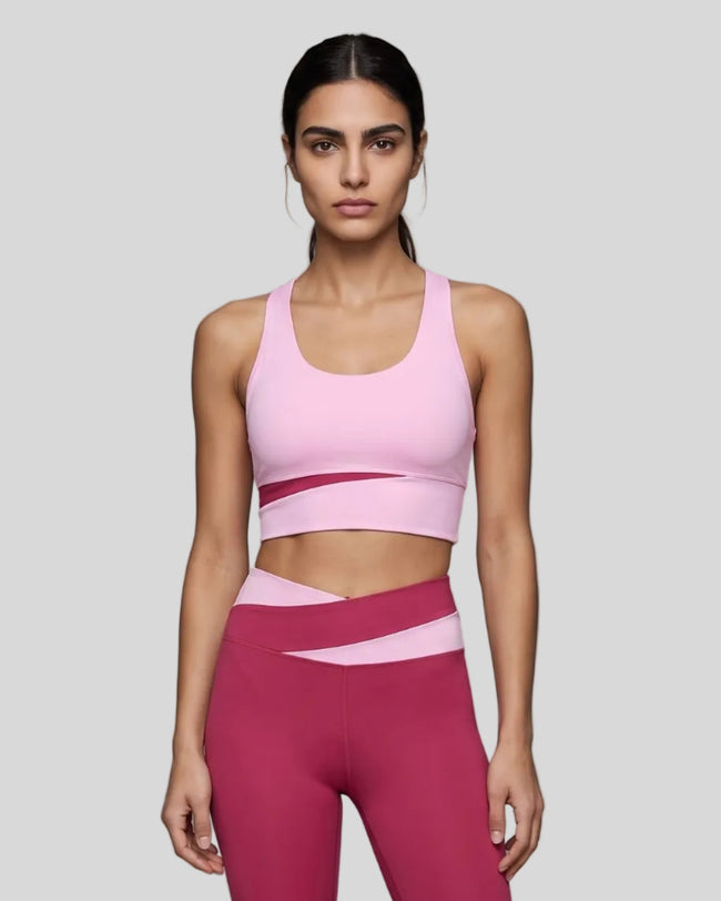 Woman wearing TrackLine Synergy Racerback Sports Bra in Rose Red with Pink detail, front view