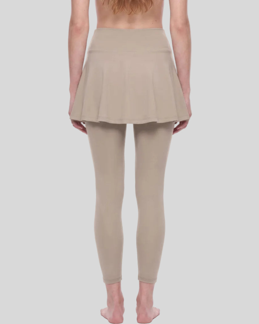Woman wearing TrackLine Synergy Skirted Leggings in Light Coffee with integrated flared skirt, lower body back view