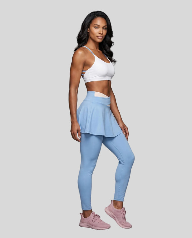 Woman wearing TrackLine Synergy Skirted Leggings in Sky Blue with Apricot crossover waistband, angled front view