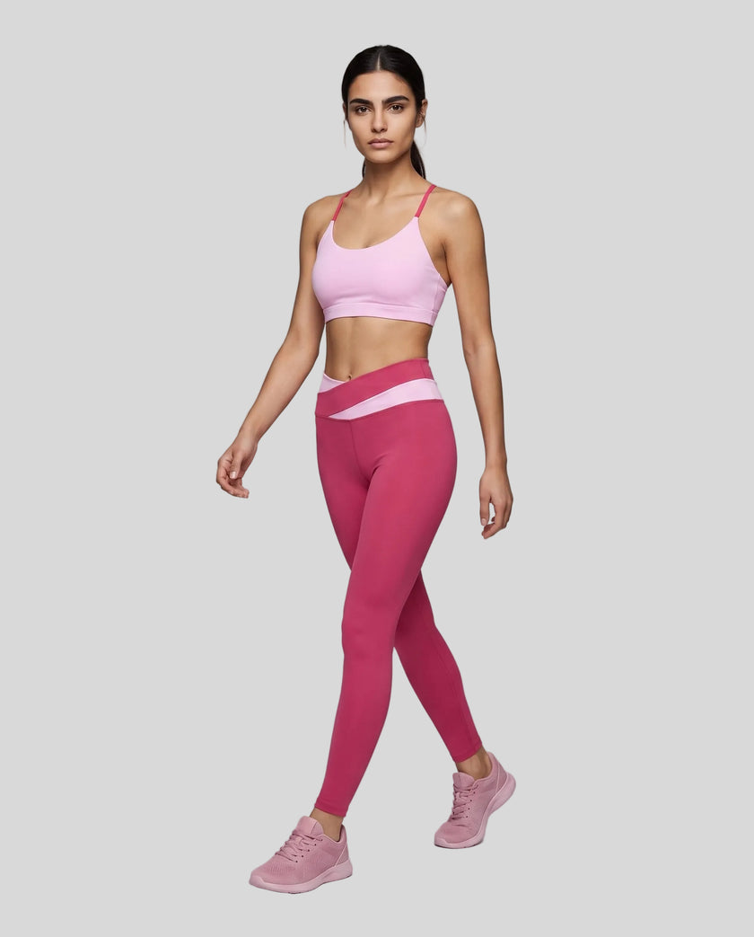 Woman wearing TrackLine Synergy Strappy Sports Bra in Pink with Rose Red, angled full-body front view
