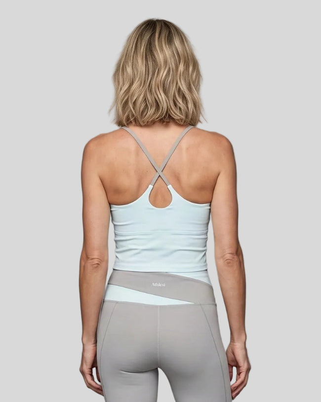 Woman wearing TrackLine Synergy Tank Top in Light Blue with Light Gray crossover straps, back view