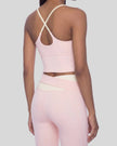 Woman wearing TrackLine Synergy Tank Top in Light Pink with Apricot straps, angled back view