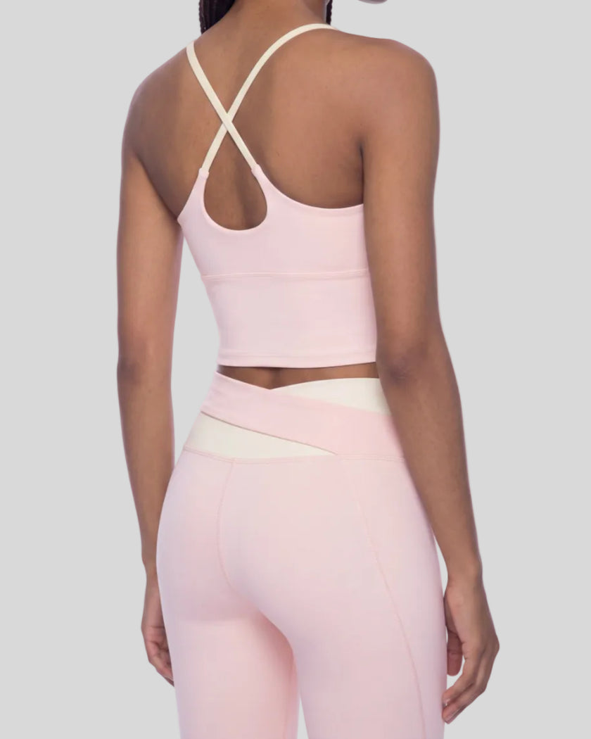 Woman wearing TrackLine Synergy Tank Top in Light Pink with Apricot straps, angled back view