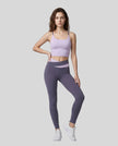 Woman modeling a Light Purple with Deep Purple TrackLine Synergy Tank Top and matching leggings, paired with white sneakers.