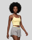 Woman wearing TrackLine Synergy Tank Top in Light Yellow with Light Gray straps, angled front view