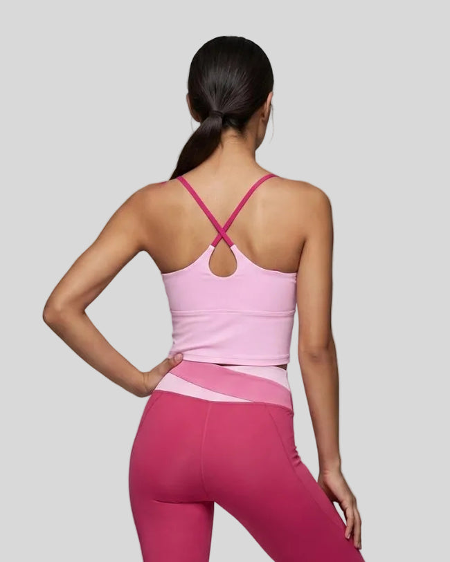 Woman wearing TrackLine Synergy Tank Top in Pink with Rose Red crossover straps, back view