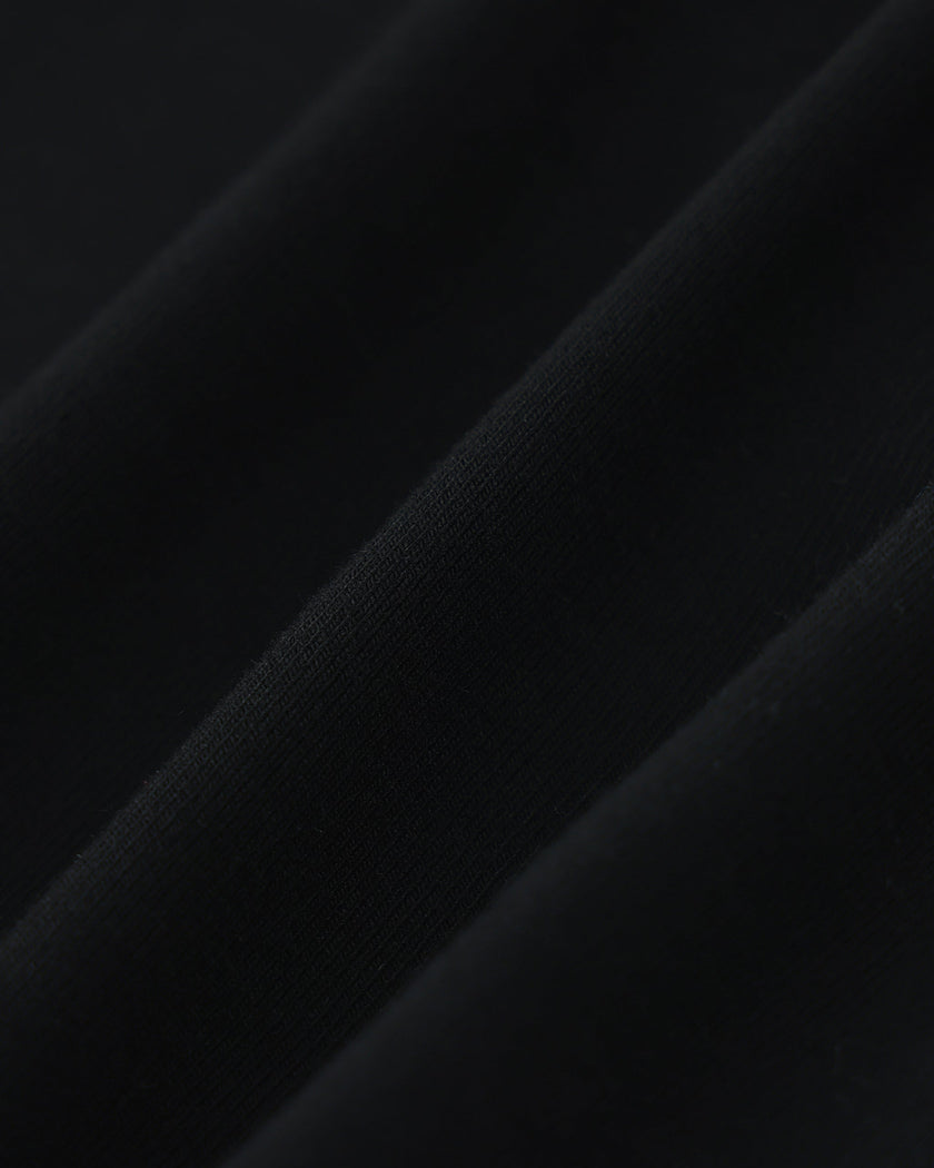 Closeup of the soft stretch fabric texture on the Athlesi TrackLine V-Neck Crop Tee in black