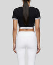 Mid body back view of the Athlesi TrackLine V-Neck Crop Tee in black