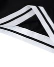 Bottom hem closeup of the Athlesi TrackLine V-Neck Crop Tee in black with striped trim detail