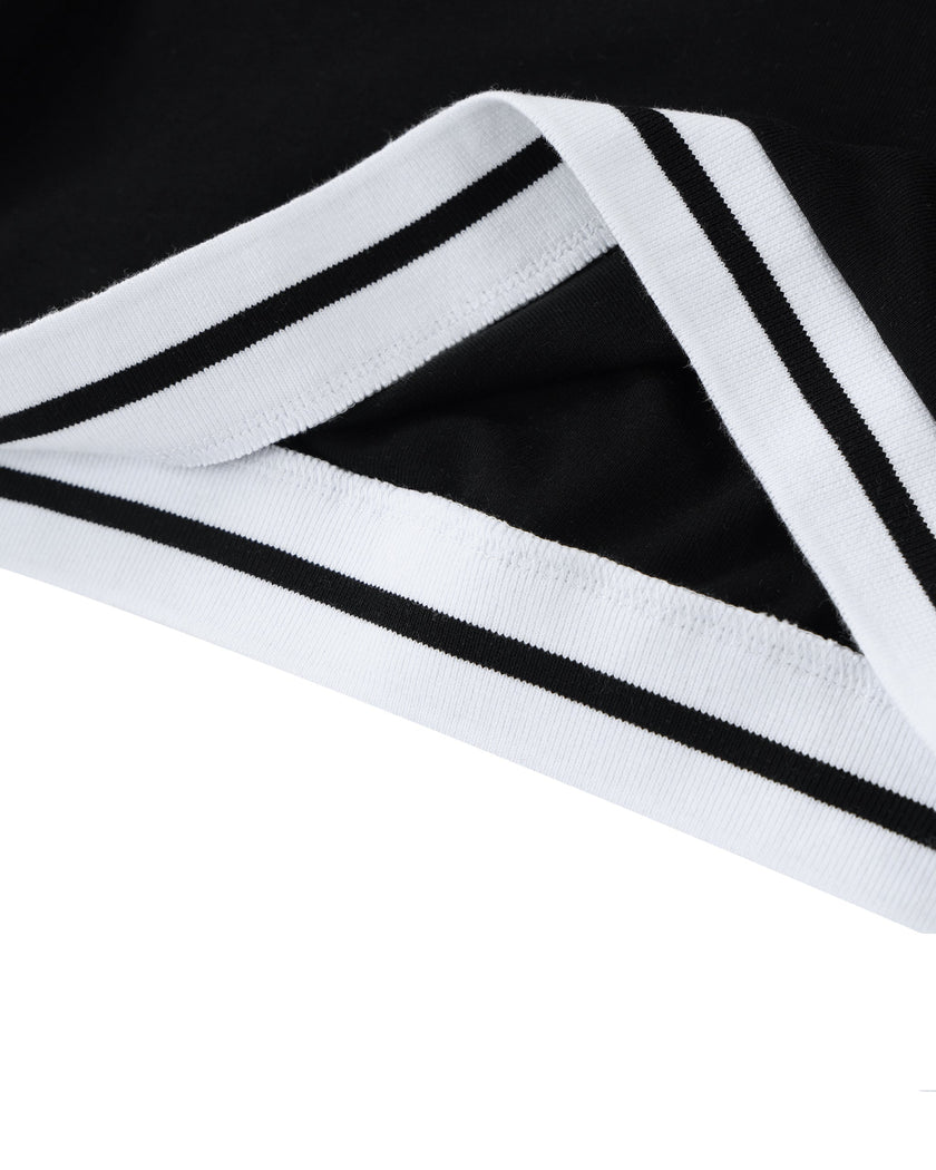 Bottom hem closeup of the Athlesi TrackLine V-Neck Crop Tee in black with striped trim detail