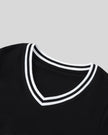 Closeup of the striped V-neck collar detail on the Athlesi TrackLine V-Neck Crop Tee in black.