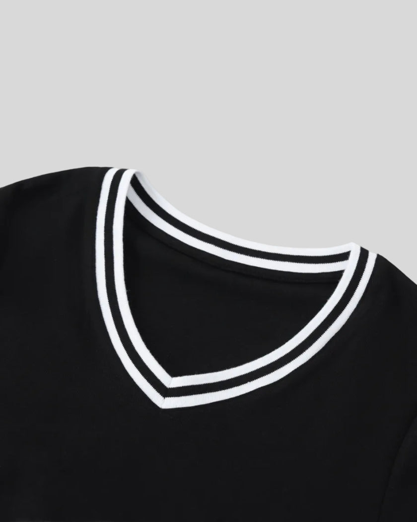 Closeup of the striped V-neck collar detail on the Athlesi TrackLine V-Neck Crop Tee in black.