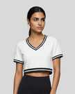 Upper body front view of a woman wearing the Athlesi TrackLine V-Neck Crop Tee in white