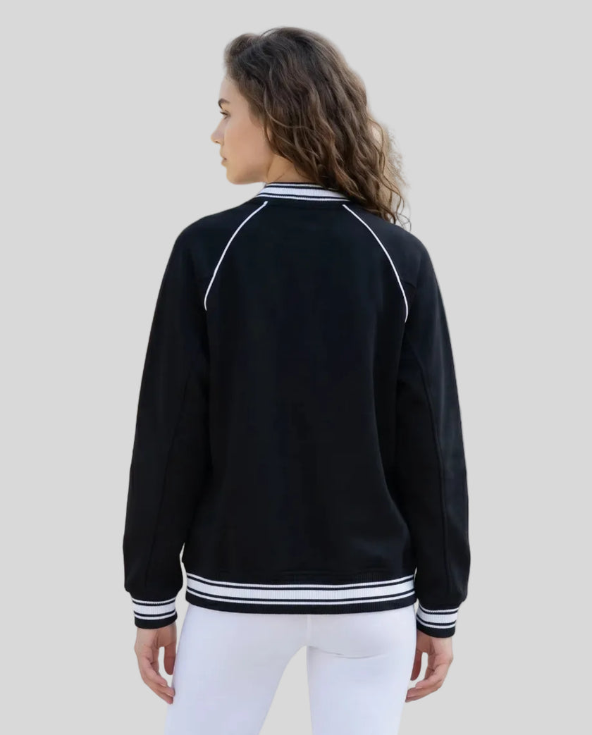 Back view of a model wearing the TrackLine Varsity Jacket in Black