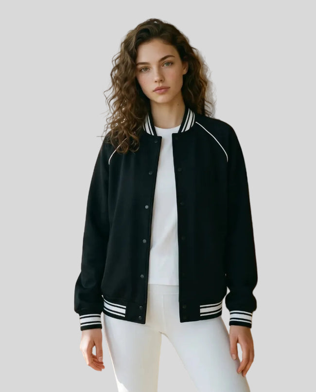 Model wearing the TrackLine Varsity Jacket in Black partially open front view