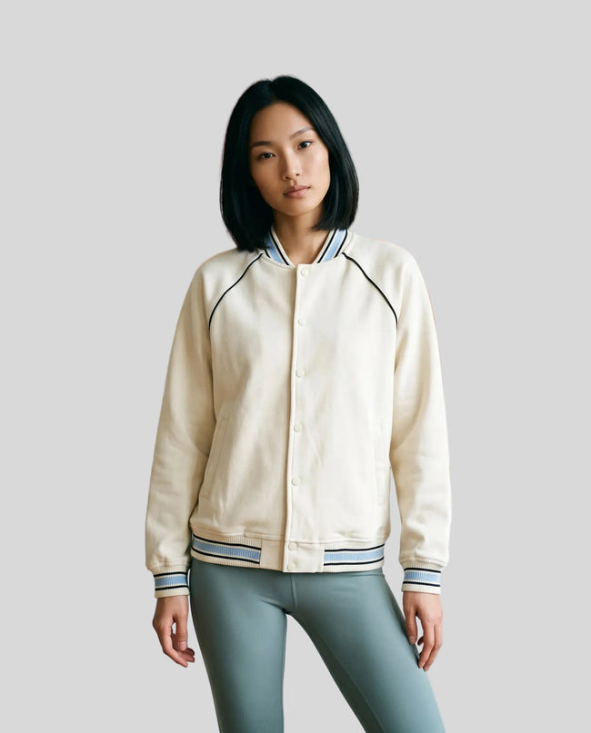 Model wearing the TrackLine Varsity Jacket in Mild Apricot fully buttoned front view