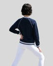 Back view of a model wearing the TrackLine Varsity Jacket in Navy Blue