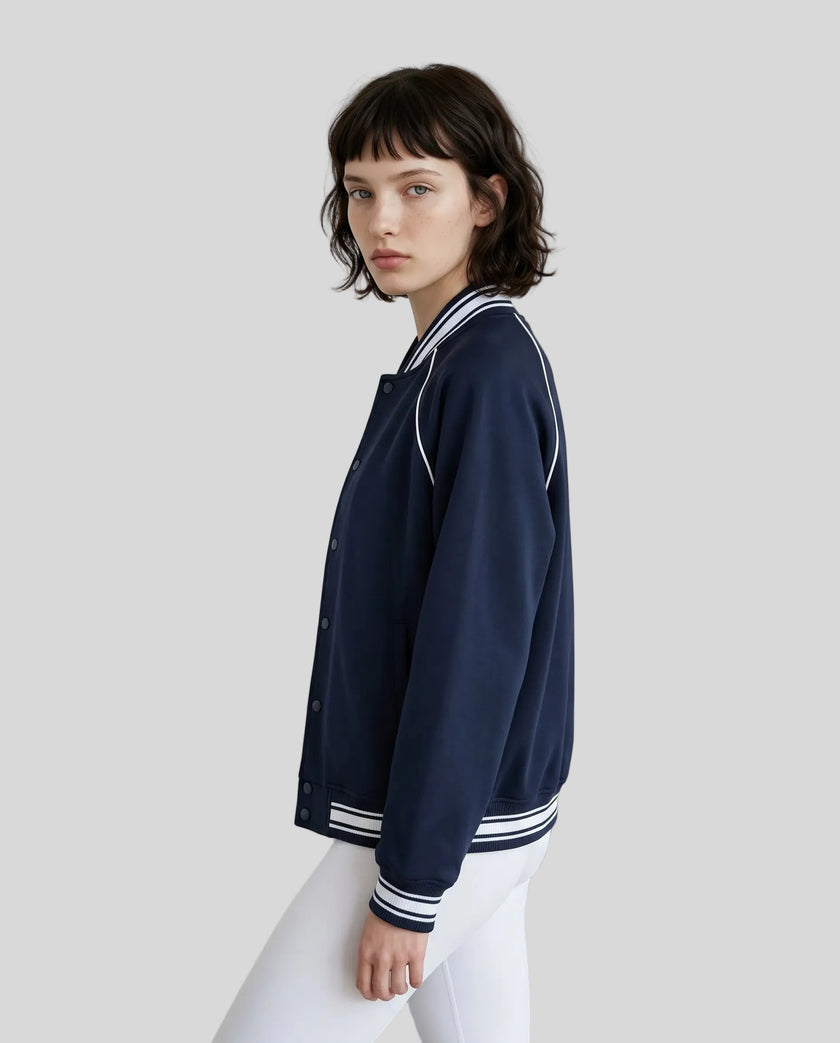 Side view of a model wearing the TrackLine Varsity Jacket in Navy Blue