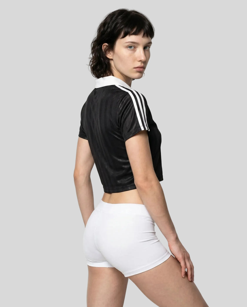 Back angle view of a woman wearing the Athlesi TrackLine Varsity Jersey in black and white