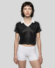 Mid body front view of a woman wearing the Athlesi TrackLine Varsity Jersey in black and white