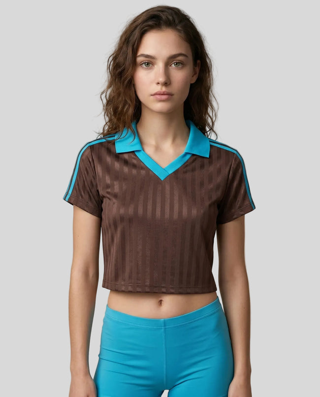 Mid body front view of a woman wearing the Athlesi TrackLine Varsity Jersey in brown and blue