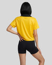 Back view of a woman wearing the Athlesi TrackLine Varsity Jersey in yellow and black