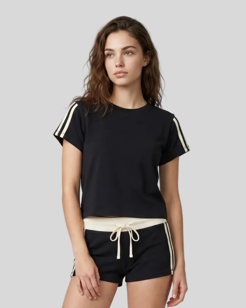 Upper body front view of a woman wearing the Athlesi TrackLine Varsity Tee in black