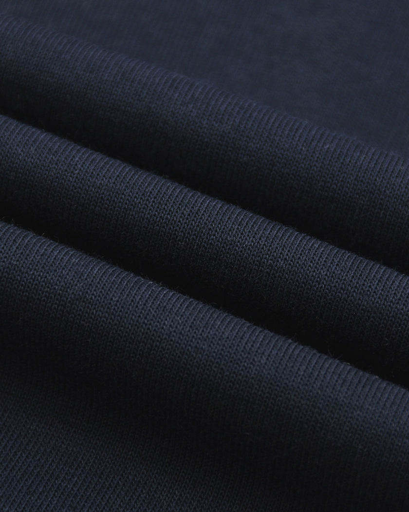 Closeup of the breathable cotton-modal fabric texture on the Athlesi TrackLine Varsity Tee in blue