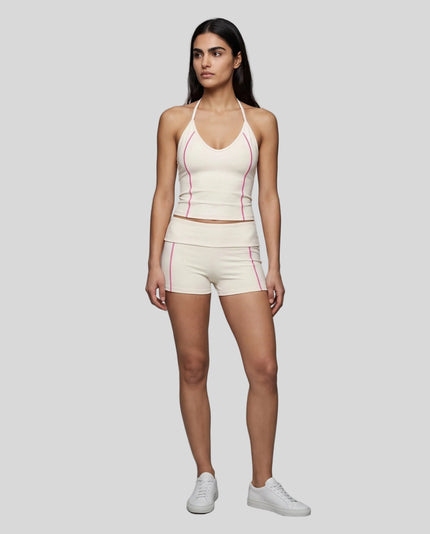 Full body front view of woman wearing apricot TrackLine Yoga Shorts with matching TrackLine Halter Yoga Top