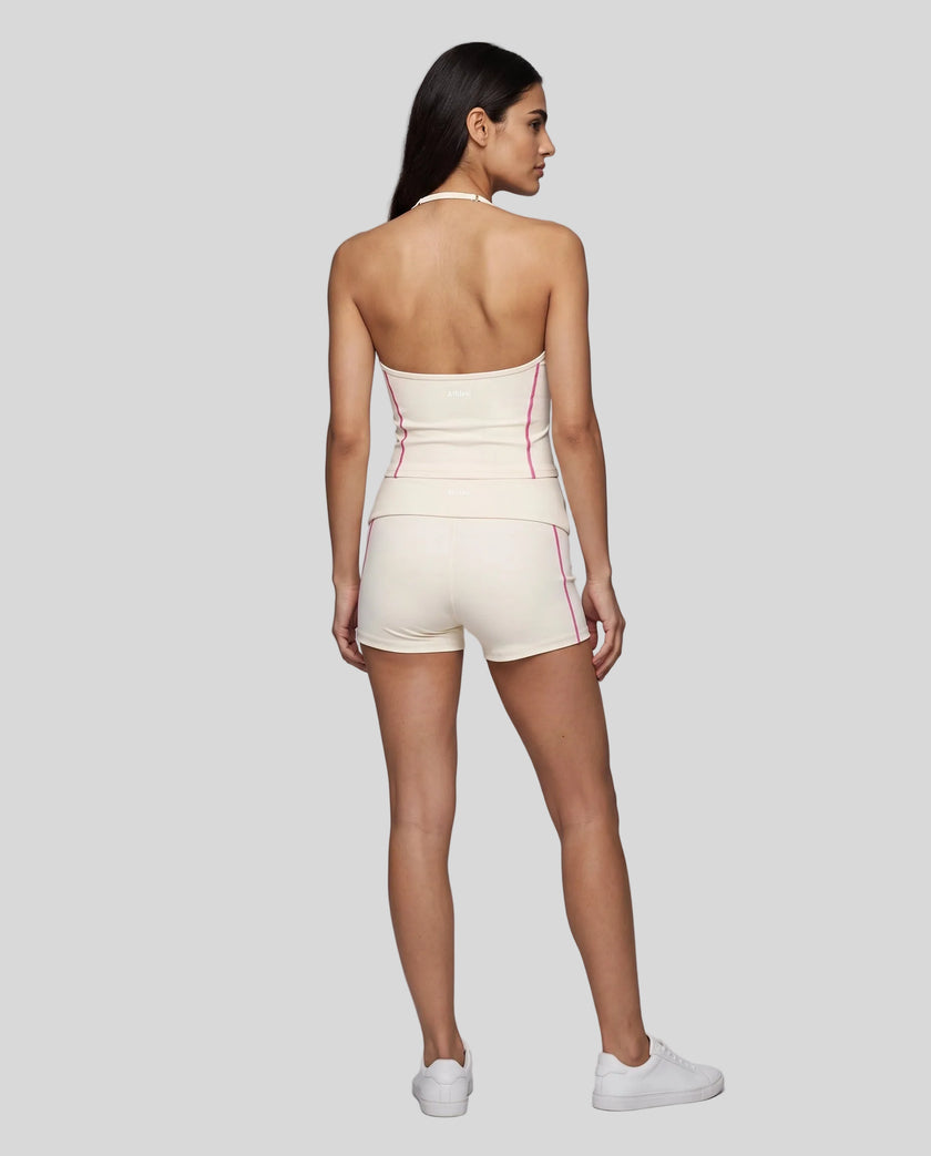 Full body back view of woman wearing apricot TrackLine Yoga Shorts with matching TrackLine Halter Yoga Top