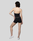 Full body back view of woman wearing black TrackLine Yoga Shorts with matching TrackLine Halter Yoga Top