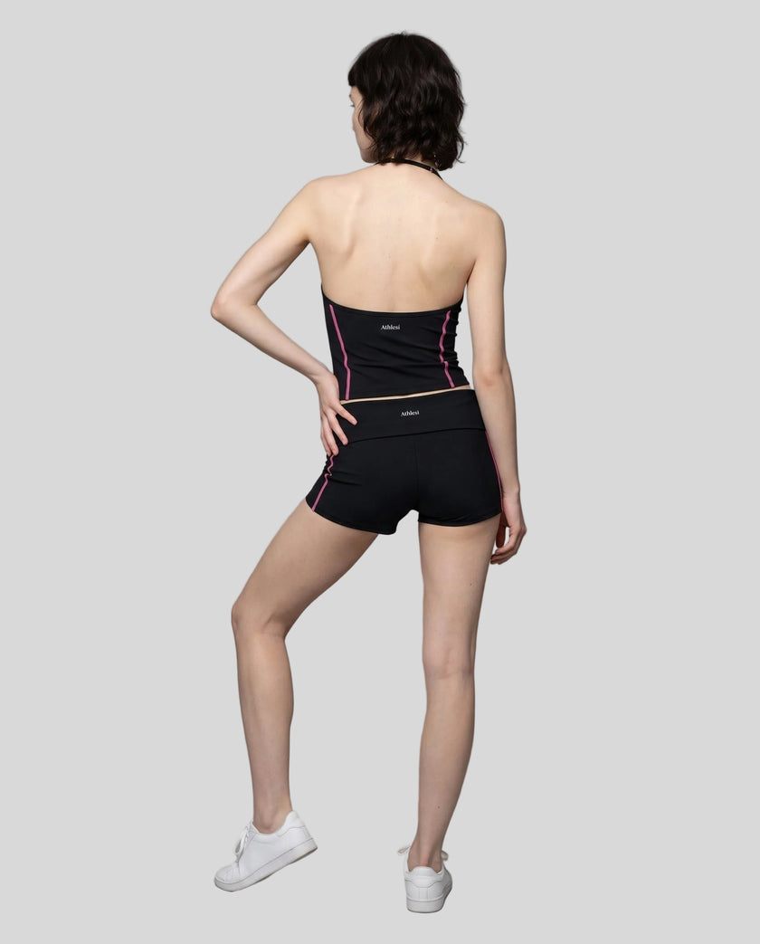 Full body back view of woman wearing black TrackLine Yoga Shorts with matching TrackLine Halter Yoga Top