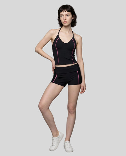 Full body front view of woman wearing black TrackLine Yoga Shorts with matching TrackLine Halter Yoga Top