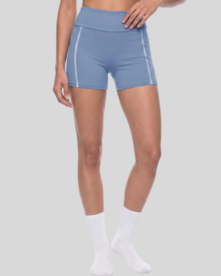 Lower body angled front view of woman wearing TrackLine Yoga Shorts in blue